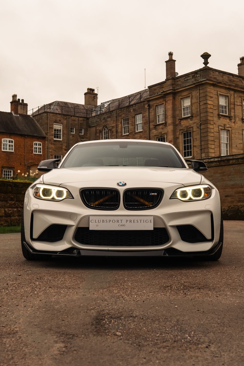 White BMW M2 head-on in front of a Georgian hall, Clubsport Prestige plate