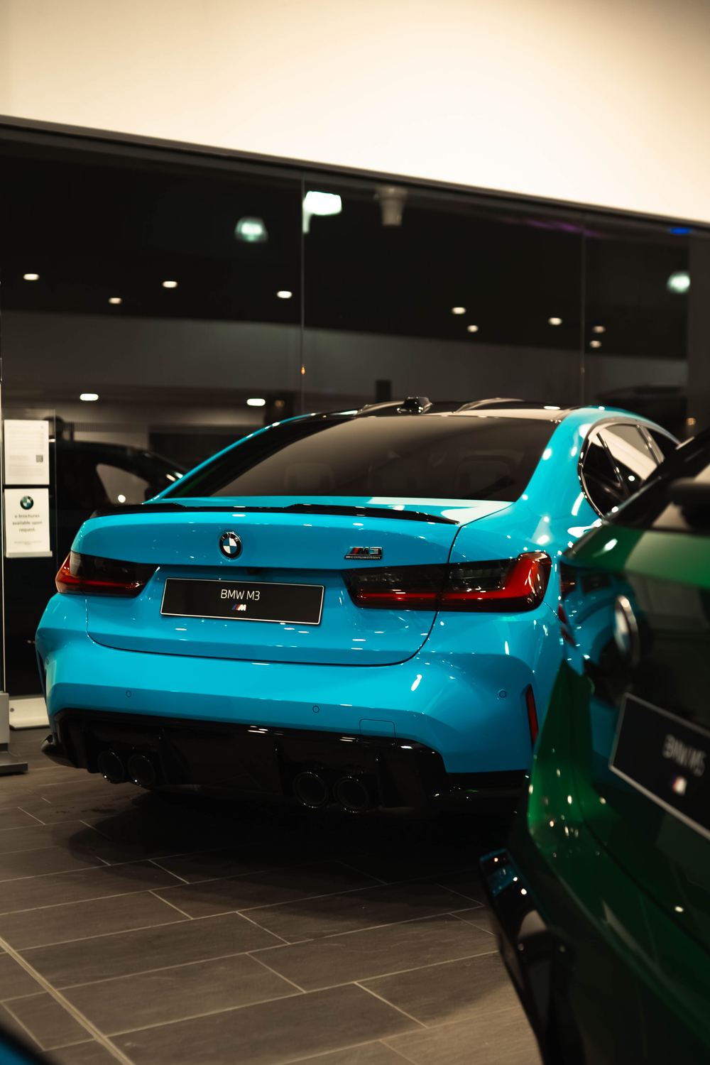 Rear of a blue BMW M3 Competition in the showroom