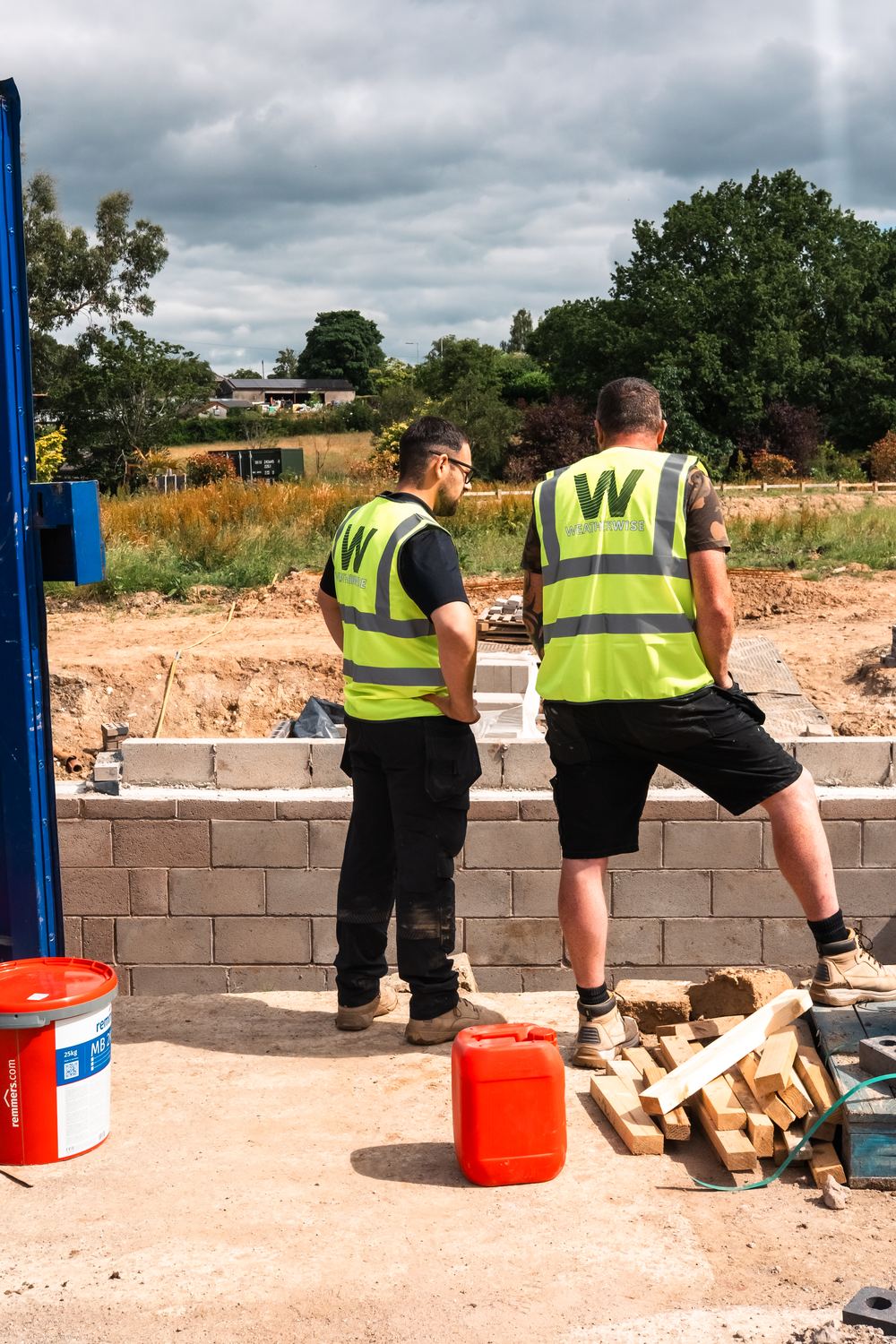 Two Weatherwise team members in hi-vis looking over new foundations