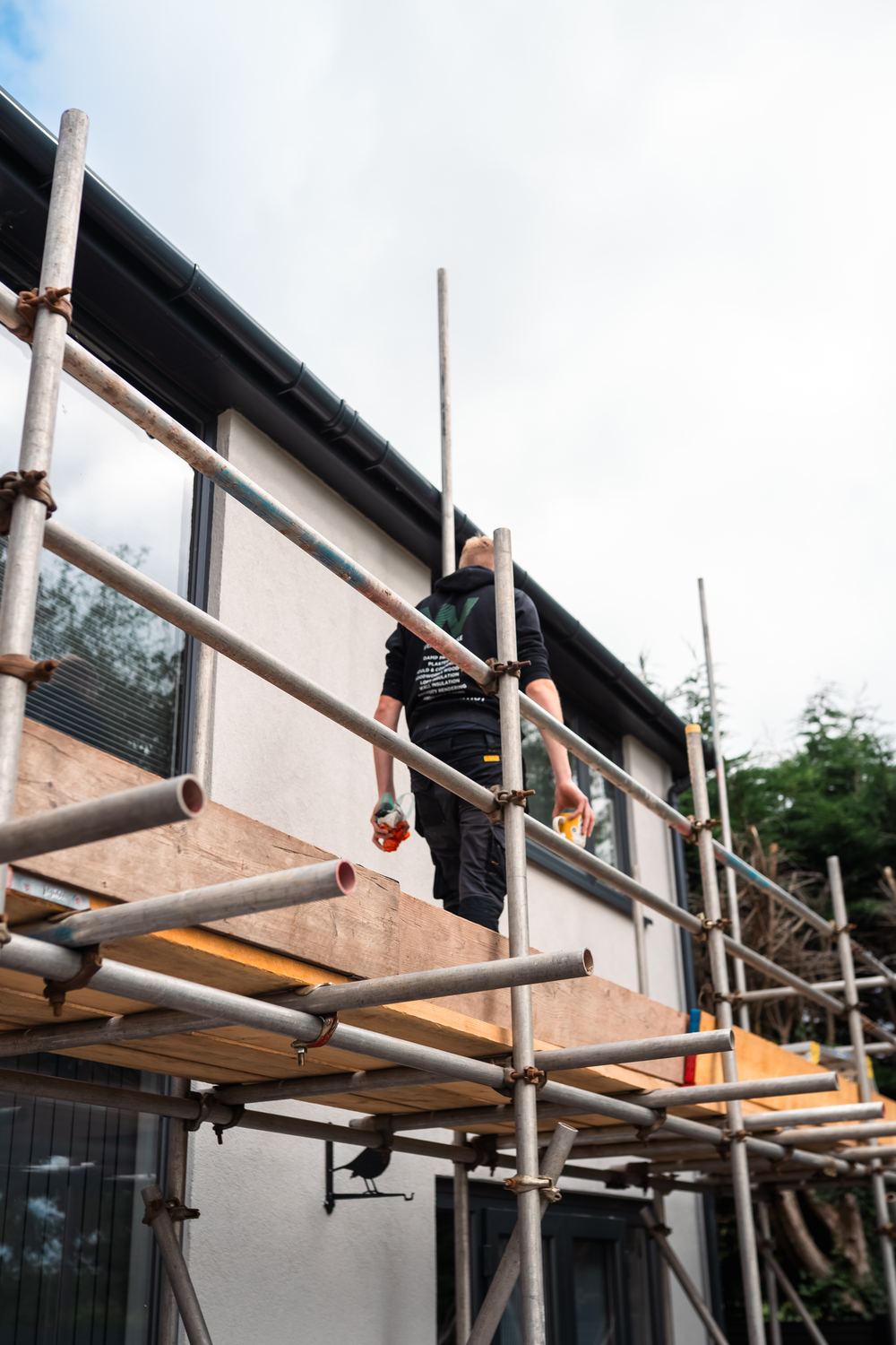 Weatherwise team member walking the scaffold on a rendering job