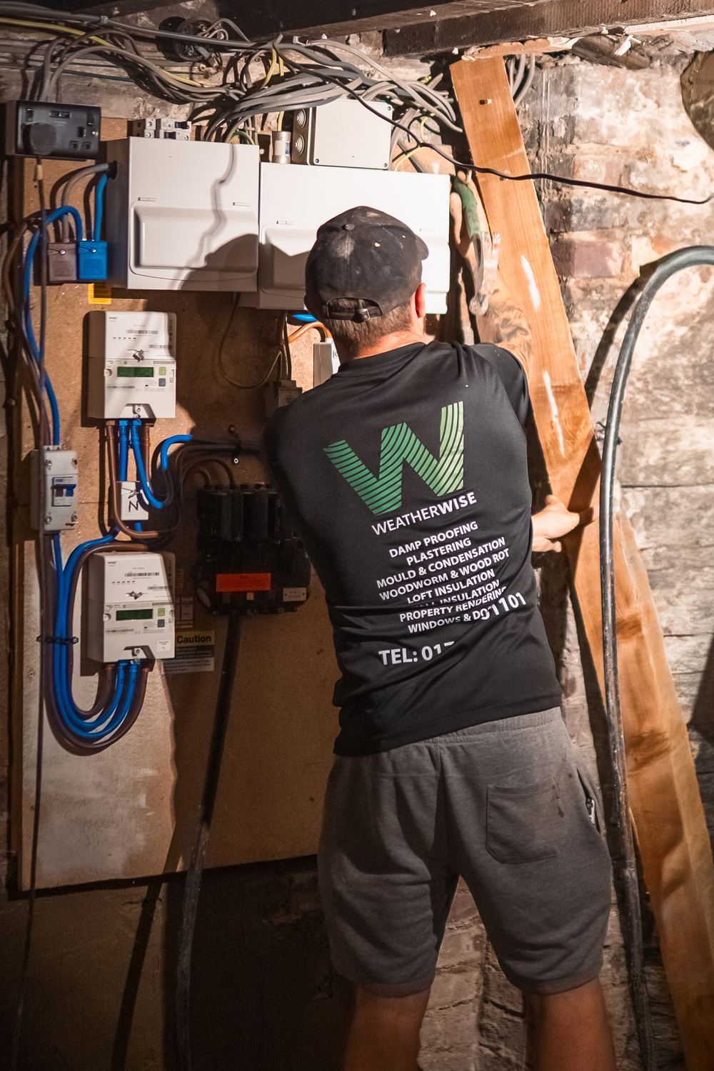 Weatherwise team member working in a cellar beside the consumer units
